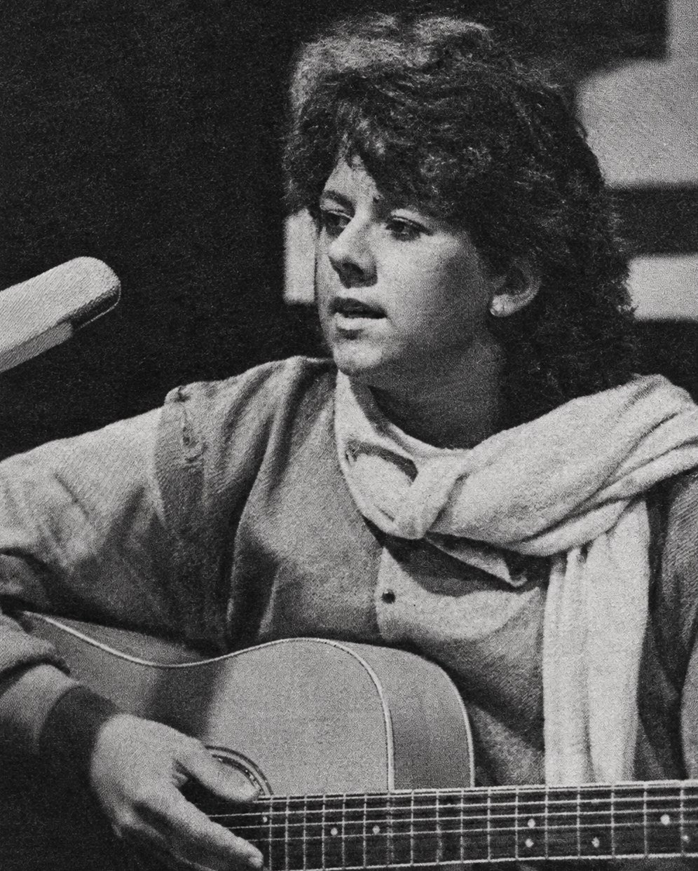 Christine Emmert singt am Mikrofon und spielt Gitarre, Schwarz-Weiß-Aufnahme